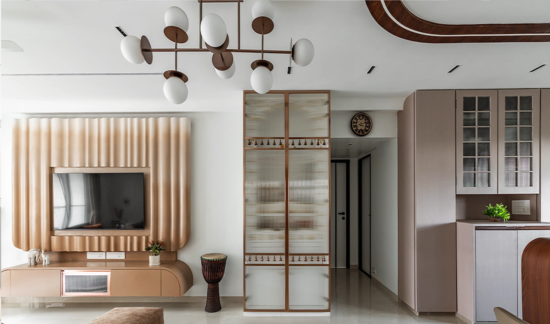 Fluted blush panelling and a curved backlit mandir in a Mumbai apartment designed by Dimora Designz